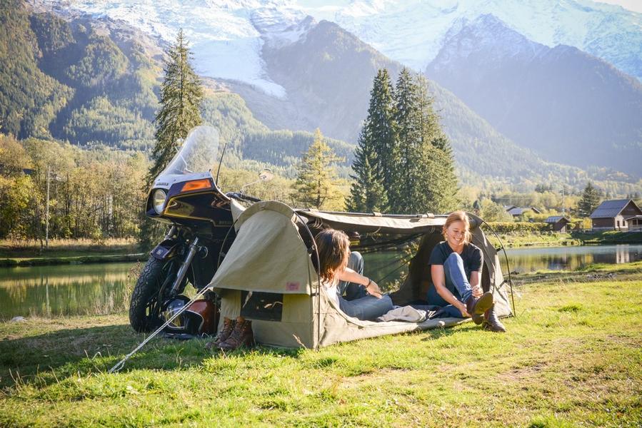 Two people outside their tent with a beautiful backdrop - on a motorcycle camping trip