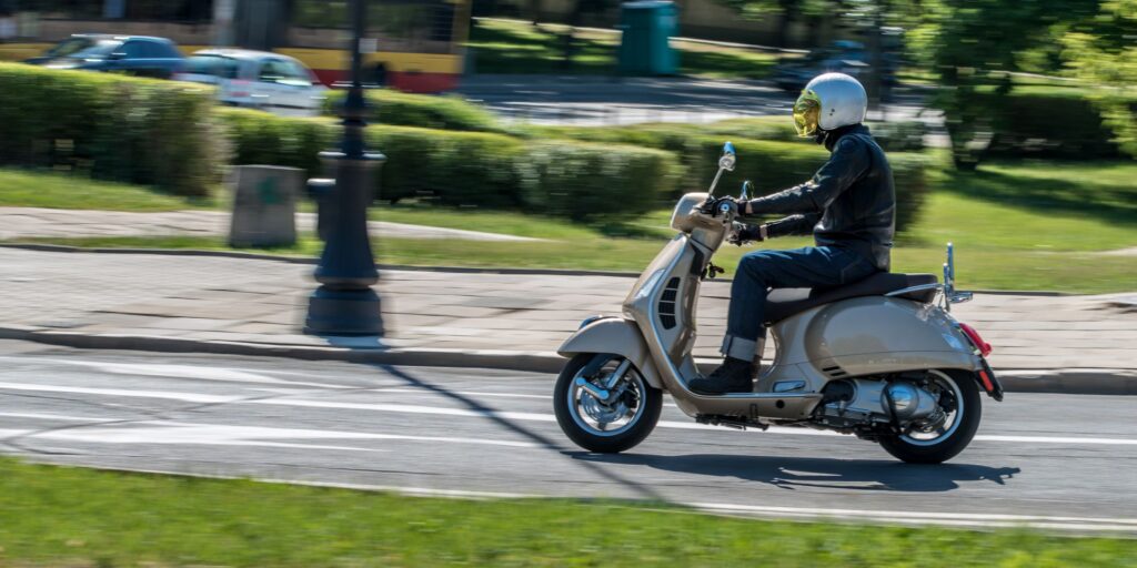 Person riding classic Vespa scooter