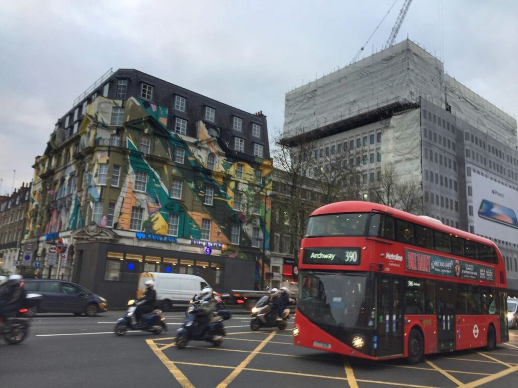 Double decker and motorbikes travel through London's rush hour